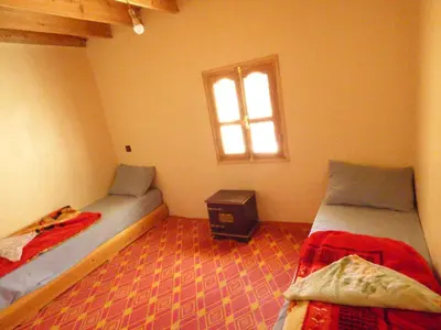 a bedroom with two beds and a window at gite taghia ahanssal in Taghia