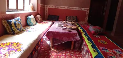 a room with a table and a couch with pillows and a table with at gite taghia ahanssal in Taghia
