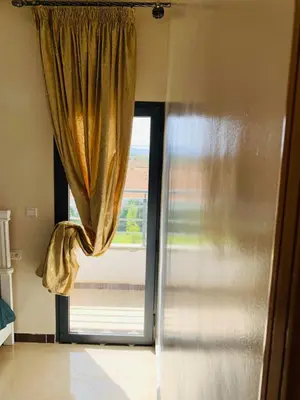 a large window with a curtain in a room at Al confort in Fès