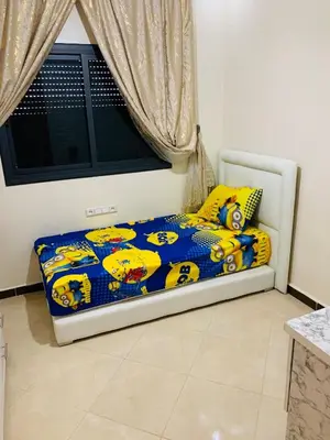 a bedroom with a bed with a yellow and blue comforter at Al confort in Fès
