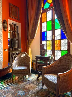 a room with chairs and a stained glass window at Kassr Annoujoum - Luxury Boutique Riad in the Heart of Fès Medina in Fès