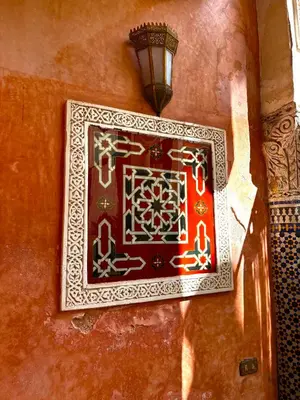 a clock on the side of a wall with a lamp at Kassr Annoujoum - Luxury Boutique Riad in the Heart of Fès Medina in Fès