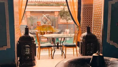 a dining room with a table and a window at Kassr Annoujoum - Luxury Boutique Riad in the Heart of Fès Medina in Fès