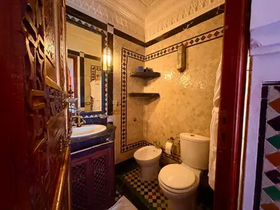 a small bathroom with a toilet and a sink at Kassr Annoujoum - Luxury Boutique Riad in the Heart of Fès Medina in Fès