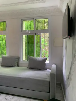 a bed sitting in a room with two windows at RIAD Jad in Fès