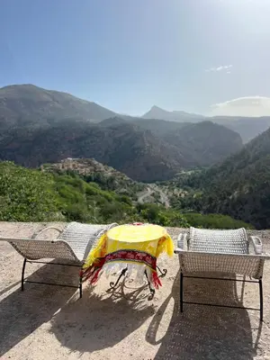 two chairs and an umbrella on top of a mountain at Dar Tissili in Aït Tamellil
