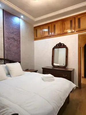 a bedroom with a white bed and a mirror at Charming Fassi Stay, 5 min Center in Fès