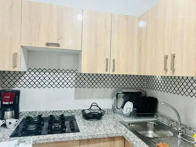 a kitchen counter with a stove and a sink at حي الامل بني ملال in Beni Mellal