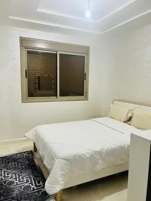 a white bedroom with a bed and a window at حي الامل بني ملال in Beni Mellal