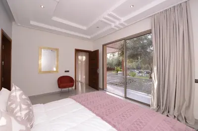 a bedroom with a bed and a large window at Villa Essalam Marrakech in Marrakech