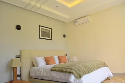 a bedroom with a large bed with orange pillows at Villa Essalam Marrakech in Marrakech