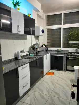 a kitchen with black and white cabinets and appliances at Rim in Fès