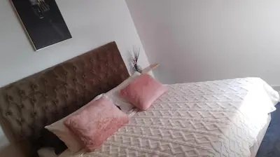 a bedroom with a bed with two pink pillows at Rim in Fès