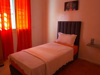 a bed in a room with red and orange curtains at Rim in Fès
