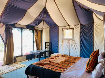 a bedroom with a bed in a tent at Merzouga Stars Luxury Camp in Merzouga