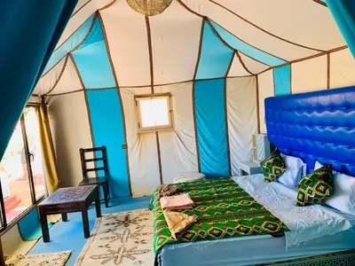 a bedroom with a bed in a tent at Merzouga Stars Luxury Camp in Merzouga