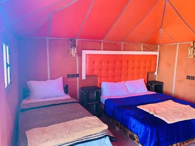 a bedroom with two beds in a tent at Merzouga Stars Luxury Camp in Merzouga