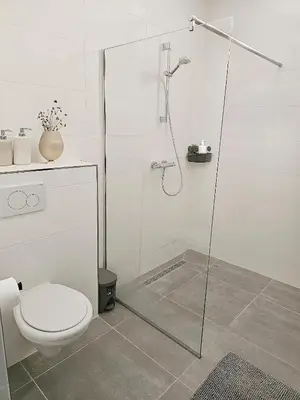 a white bathroom with a shower and a toilet at Family Stay Ourzazate - Deluxe Appartments in Ouarzazate