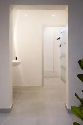 a bathroom with white walls and a white door at Family Stay Ourzazate - Deluxe Appartments in Ouarzazate