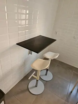 a black counter and two stools in a room at Family Stay Ourzazate - Deluxe Appartments in Ouarzazate