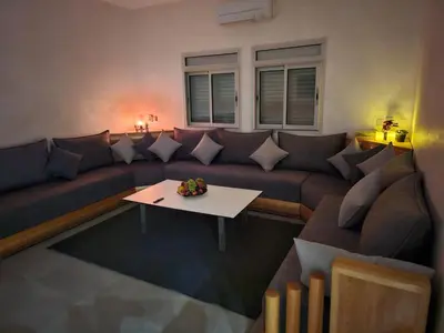 a living room with a couch and a table at Family Stay Ourzazate - Deluxe Appartments in Ouarzazate