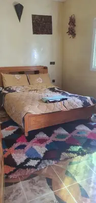 a bed in a bedroom with a rug on the floor at Park tazeka in Bistouna