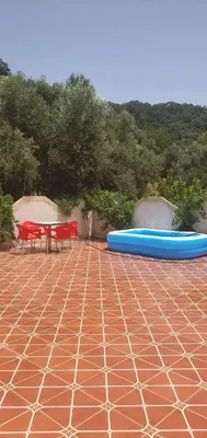 a patio with a table and two blue boats on it at Park tazeka in Bistouna