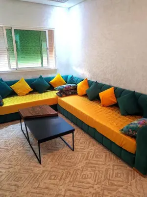 a couch with colorful pillows on it in a room at Comfortable apartment Meknes in Meknès