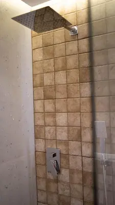 a tiled bathroom with a shower with a shower head at Penthouse-fes in Fès