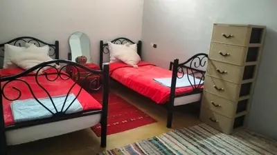 a bedroom with two beds and a dresser in it at Kasbat Taslit chez l'habitant in Tajda