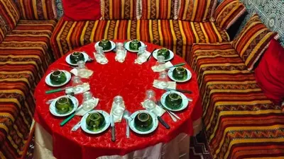a table with plates and dishes on a couch at Kasbat Taslit chez l'habitant in Tajda