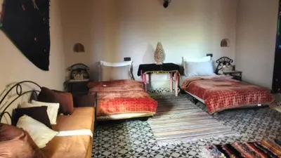 a bedroom with two beds and a couch at Kasbat Taslit chez l'habitant in Tajda