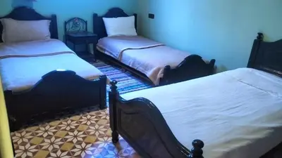 two beds sitting in a room with at Kasbat Taslit chez l'habitant in Tajda