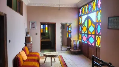 a living room with a couch and a stained glass window at Kasbat Taslit chez l'habitant in Tajda