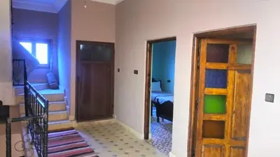 a hallway with a door and a room with a bed at Kasbat Taslit chez l'habitant in Tajda