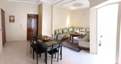 a living room with a table and a couch at Beautiful apartment near airport in Fès