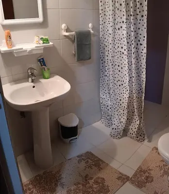 a bathroom with a sink and a shower curtain at Beautiful apartment near airport in Fès