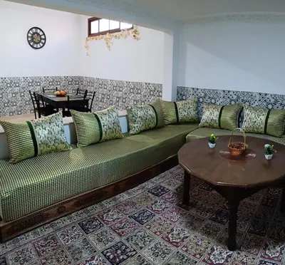 a living room with a green couch and a table at Chez Khalid, near airport in Fès