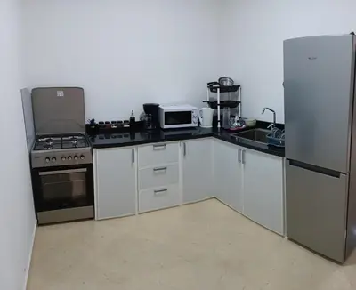 a kitchen with a stove and a refrigerator at Chez Khalid, near airport in Fès