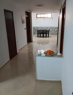 a room with a table with a bowl of fruit on a counter at Chez Khalid, near airport in Fès