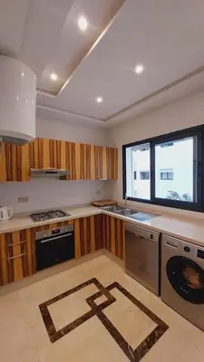 a kitchen with a washer and dryer and a window at Tanger Apt Near Train & Mall in Oulad Akkou