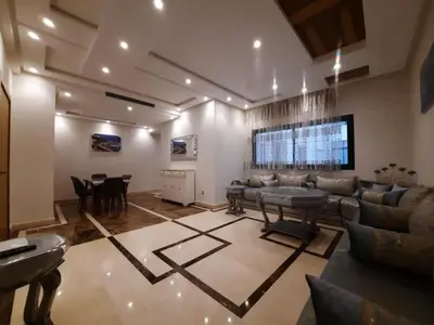 a living room with a couch and a table at Tanger Apt Near Train & Mall in Oulad Akkou