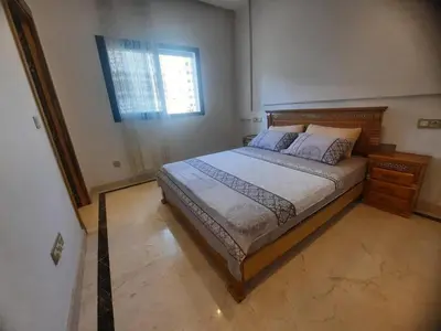 a bedroom with a large bed and a window at Tanger Apt Near Train & Mall in Oulad Akkou