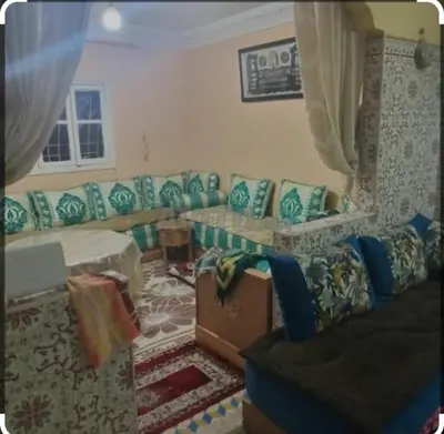 a living room with a couch and a window at Maison Zakaria in Zaouiat Cheikh