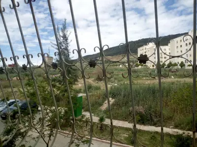 a fence with a view of a field behind it at Appartement Ghita in Fès