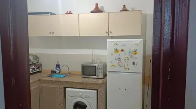 a kitchen with a refrigerator and a microwave at Appartement Ghita in Fès