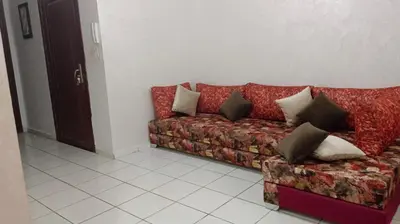 a red couch with pillows in a living room at Appartement Ghita in Fès
