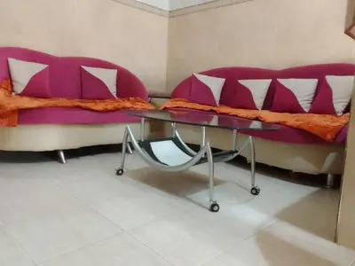 a purple couch and a glass table in a room at Joli appartement de 120 m2 in Meknès