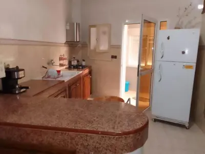 a kitchen with a counter and a white refrigerator at Joli appartement de 120 m2 in Meknès