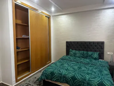 a small bedroom with a bed and a closet at Appartement Familial Spacieux Confort et Tranquillité Assurés in Oulad Akkou